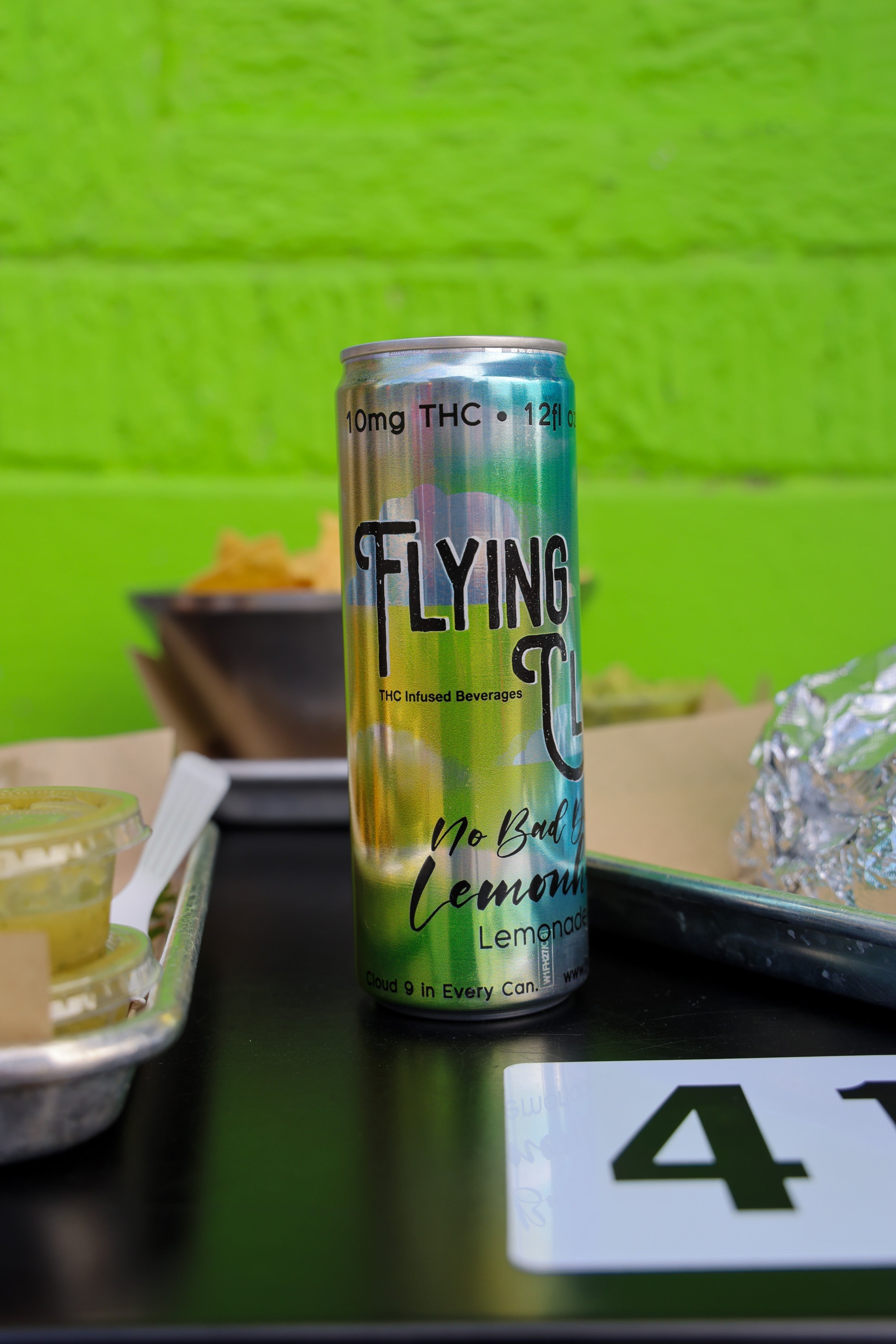 Can of Delta 9 THC drink on a table with a green background